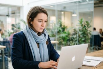 Jeune femme concentrée travaillant à son bureau moderne